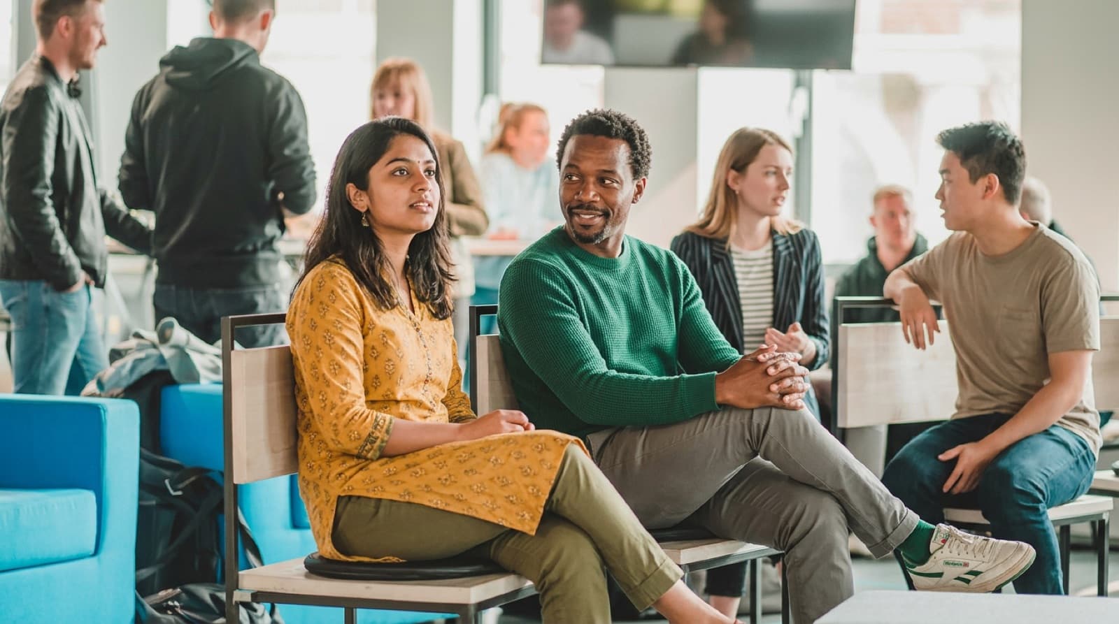 Gäste eines Meetups auf Stühlen im Gespräch